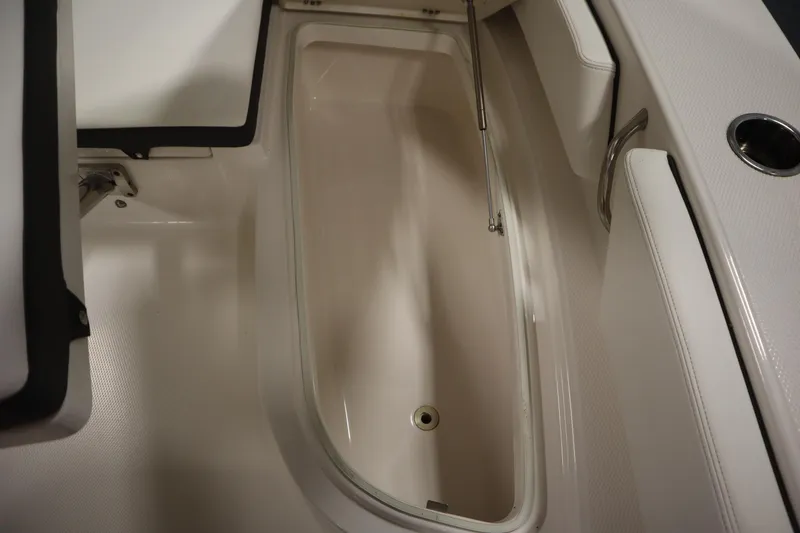 Slide: The Image of 2022 Robalo 246 Cayman storage compartment with open lid and hydraulic support. - 23