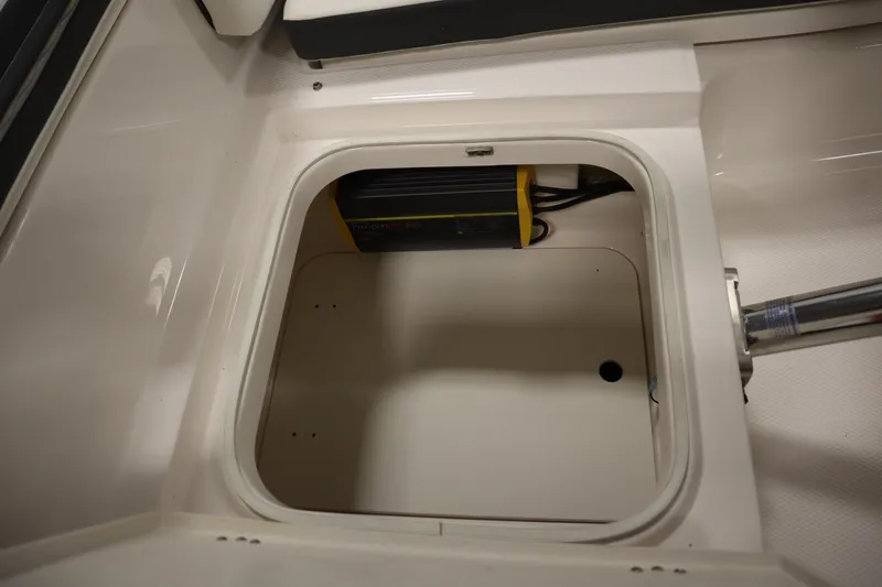 Slide: The Image of 2022 Robalo 246 Cayman storage compartment with electrical components. - 24