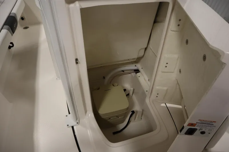 Slide: The Image of 2022 Robalo 246 Cayman boat storage compartment with open hatch and visible interior. - 28