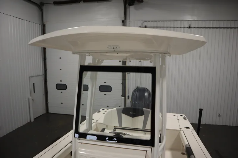 Slide: The Image of 2022 Robalo 246 Cayman boat in indoor storage, showcasing T-top and console. - 30