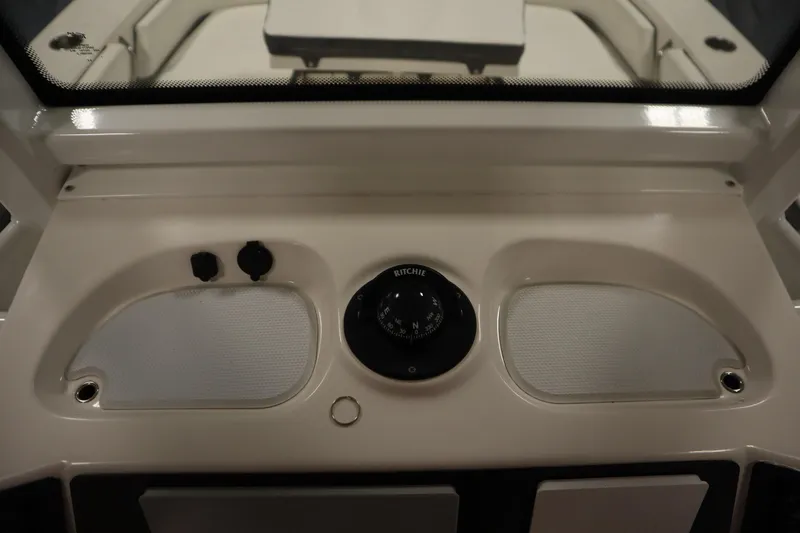 Slide: The Image of 2022 Robalo 246 Cayman dashboard with compass and controls. - 36
