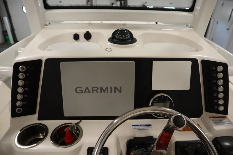 Slide: The Image of 2022 Robalo 246 Cayman boat dashboard with Garmin navigation system and steering wheel. - 47