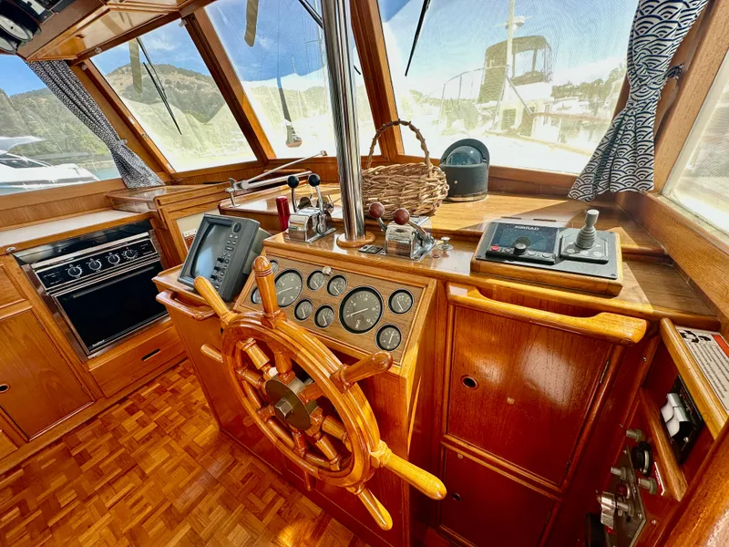 Slide: The Image of 1989 Grand Banks 42 Classic helm with wooden wheel, navigation instruments, and panoramic windows. - 10