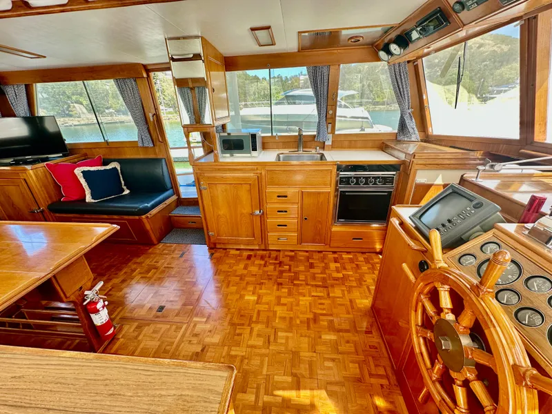 Slide: The Image of Interior of 1989 Grand Banks 42 Classic yacht with wooden helm, kitchen, and seating area. - 15