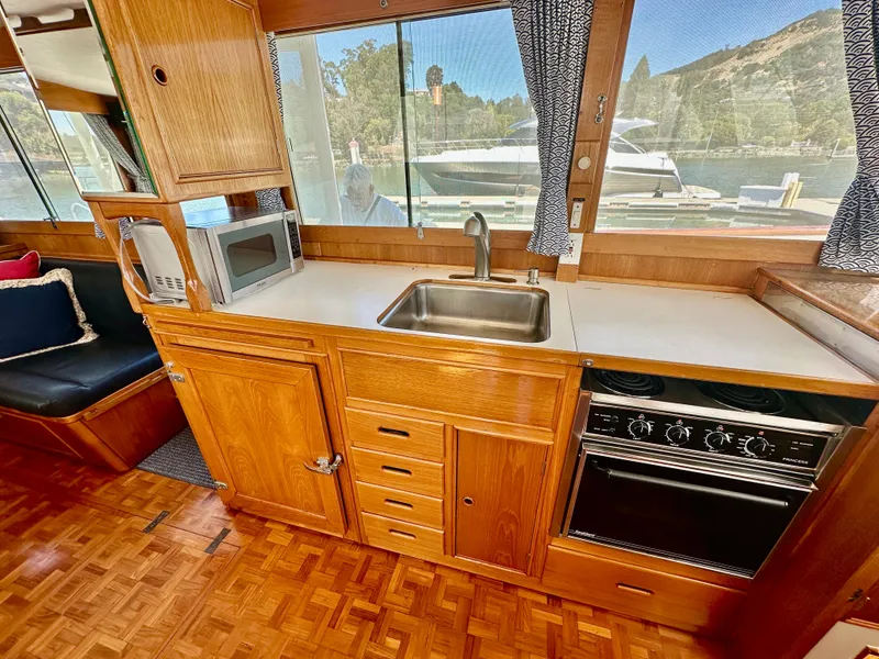 Slide: The Image of 1989 Grand Banks 42 Classic yacht kitchen with wood cabinetry, sink, stove, and microwave. - 19