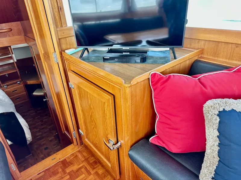 Slide: The Image of Interior of 1989 Grand Banks 42 Classic with TV, wooden cabinetry, and colorful cushions. - 29