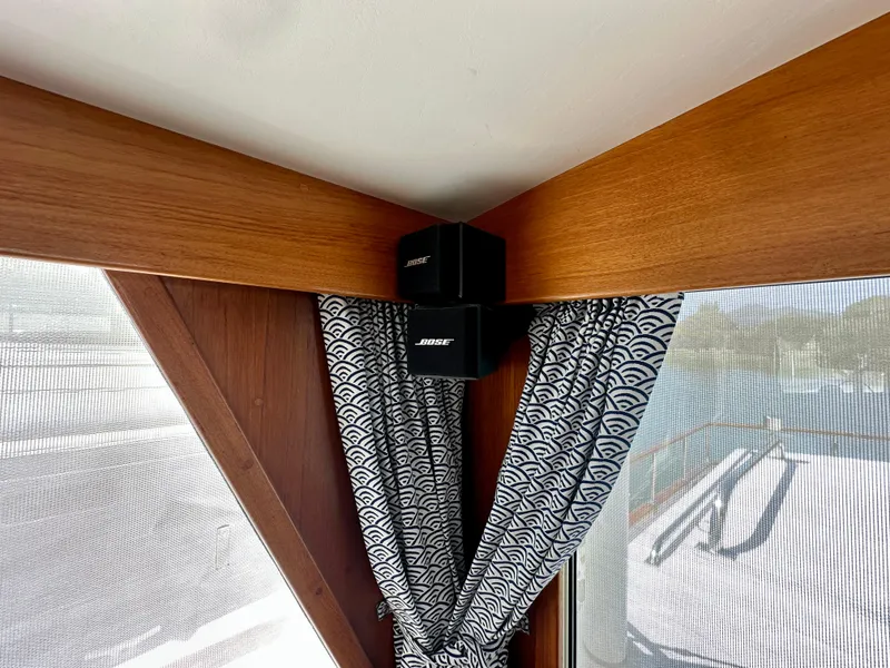 Slide: The Image of Bose speakers mounted in a 1989 Grand Banks 42 Classic yacht interior with patterned curtains. - 32