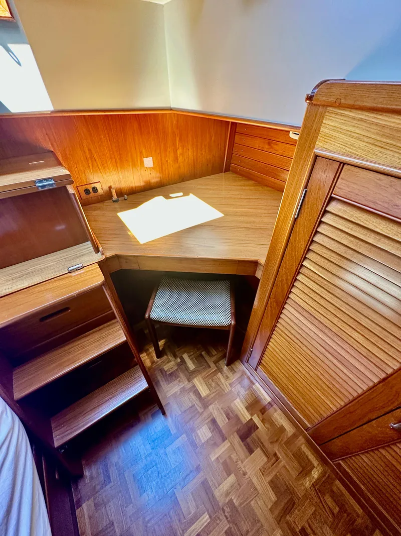 Slide: The Image of 1989 Grand Banks 42 Classic interior with wooden desk, chair, and parquet flooring. - 43