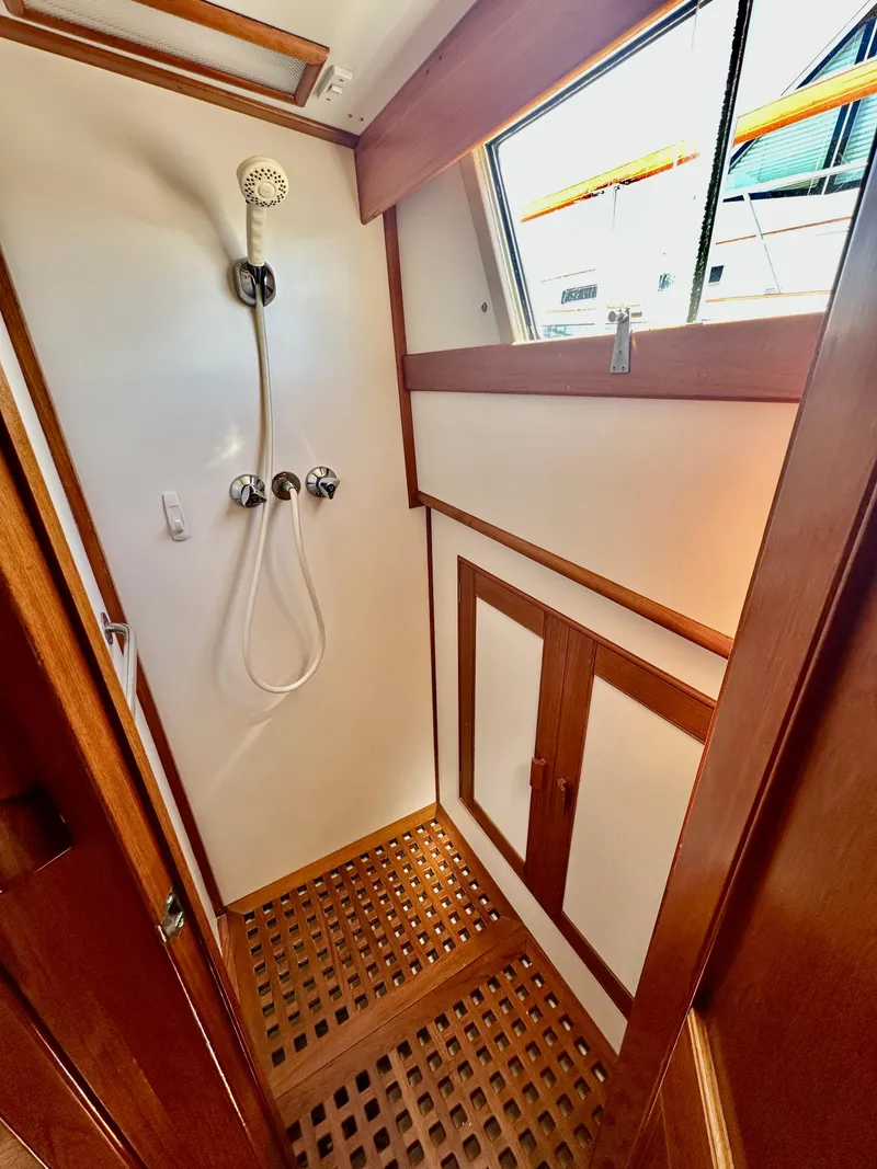 Slide: The Image of Shower area in 1989 Grand Banks 42 Classic yacht with wooden accents and window. - 48