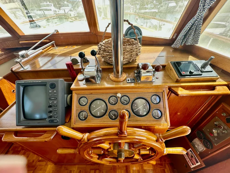 Slide: The Image of Helm of 1989 Grand Banks 42 Classic yacht with wooden wheel and navigation instruments. - 9