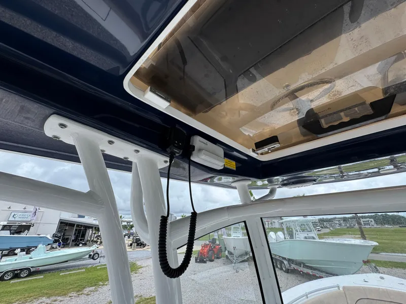 Slide: The Image of 2020 Sportsman Open 282TE Center Console boat interior with overhead storage and view of marina. - 32