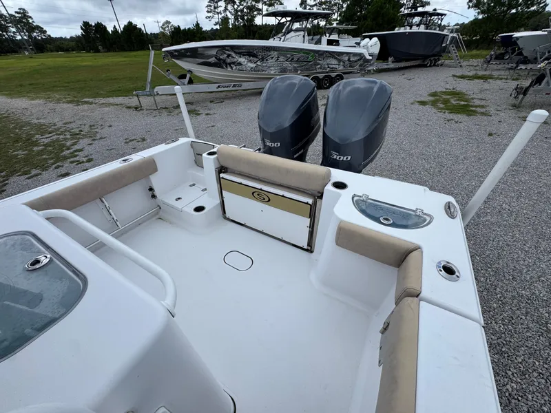 Slide: The Image of 2020 Sportsman Open 282TE Center Console boat with dual engines, parked on gravel. - 41