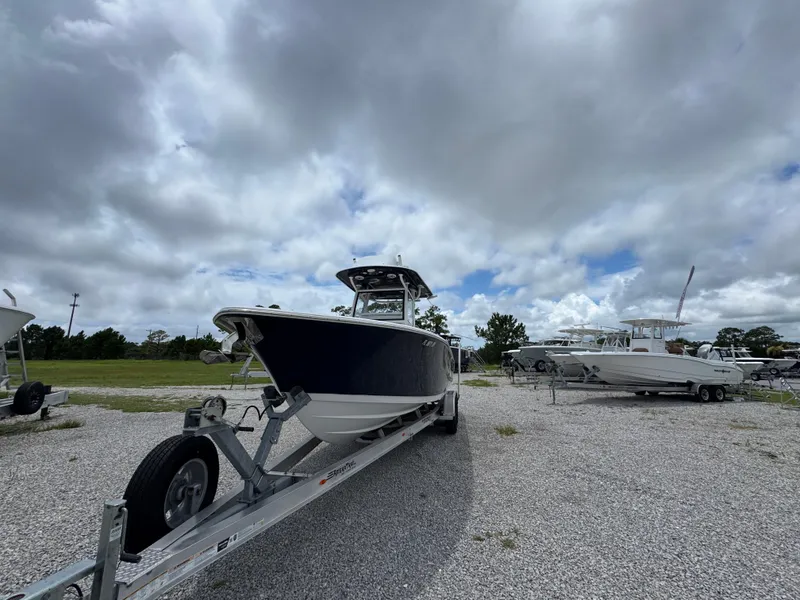 Slide: The Image of 2020 Sportsman Open 282TE Center Console boat on trailer under cloudy sky. - 7