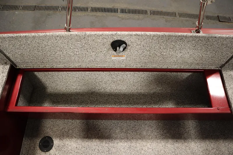 Slide: The Image of 2023 Polar Kraft Outlander DC boat storage compartment with red trim and gray interior. - 43