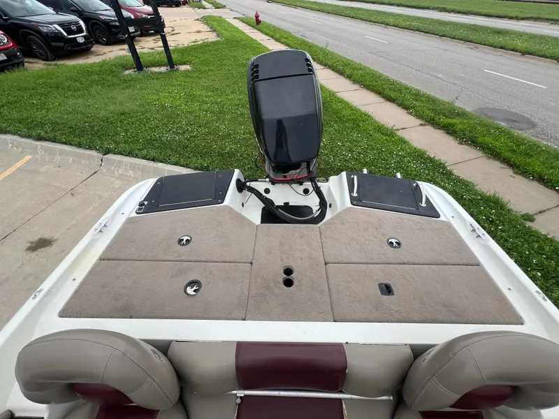 Slide: The Image of 2004 Ranger 180 Reata boat with outboard motor, parked near grass and road. - 6