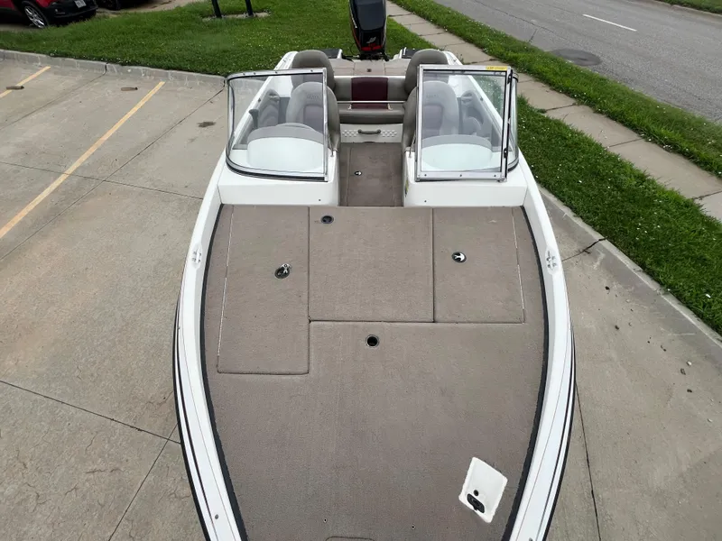 Slide: The Image of 2004 Ranger 180 Reata boat with open cockpit and seating, parked on pavement. - 9