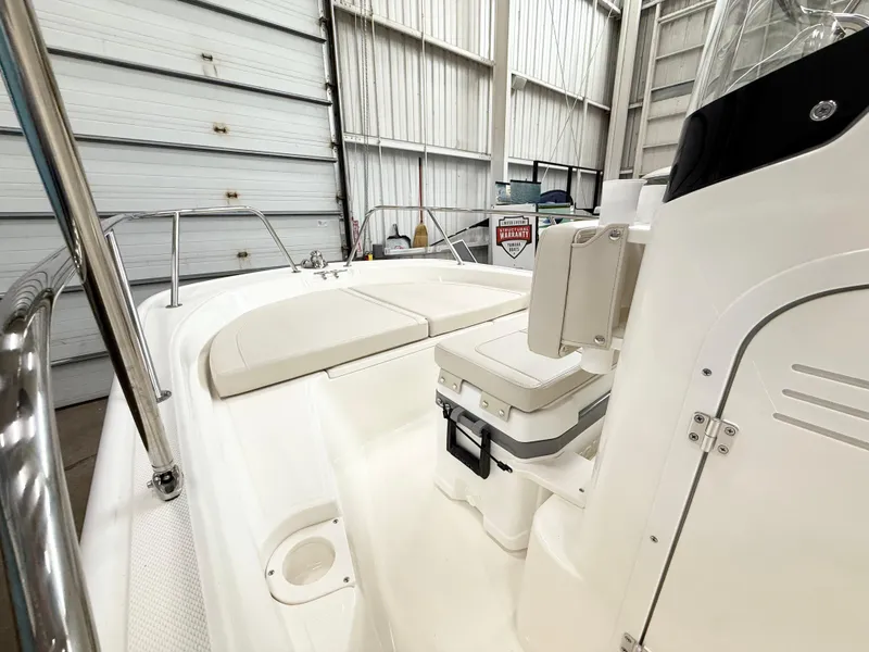 Slide: The Image of 2025 Boston Whaler 150 Montauk boat interior with seating and storage in a garage. - 10