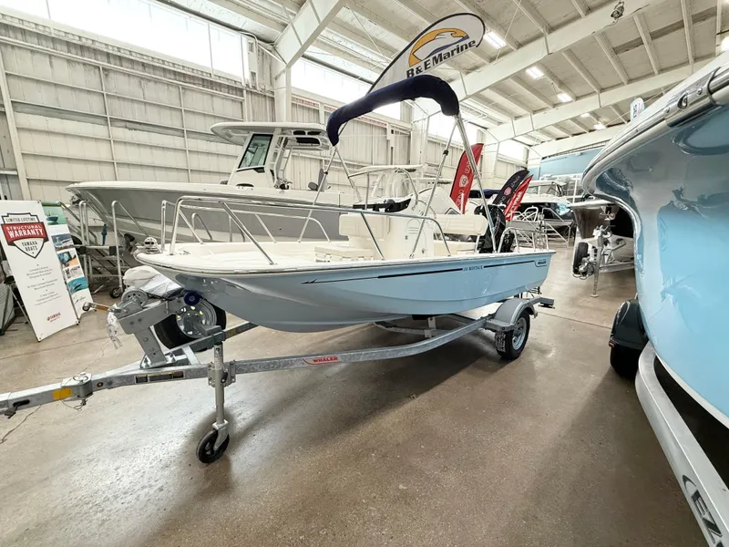 Slide: The Image of 2025 Boston Whaler 150 Montauk boat displayed indoors on a trailer. - 2