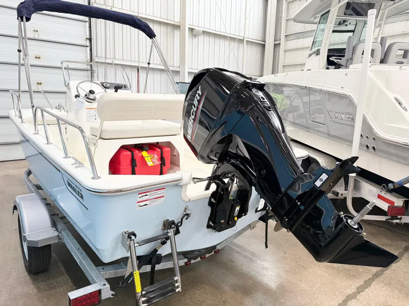 Slide: The Image of 2025 Boston Whaler 150 Montauk boat with Mercury outboard motor in a showroom. - 3