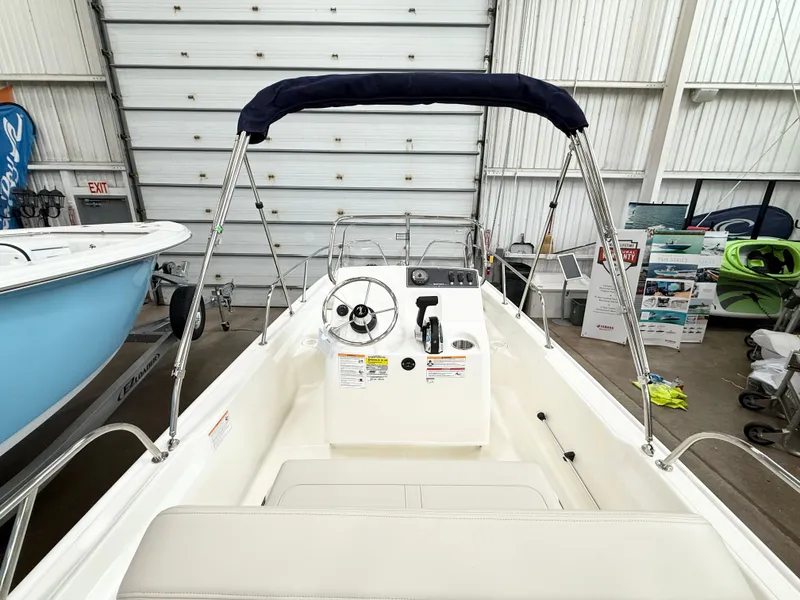 Slide: The Image of 2025 Boston Whaler 150 Montauk boat interior with steering console and seating. - 5
