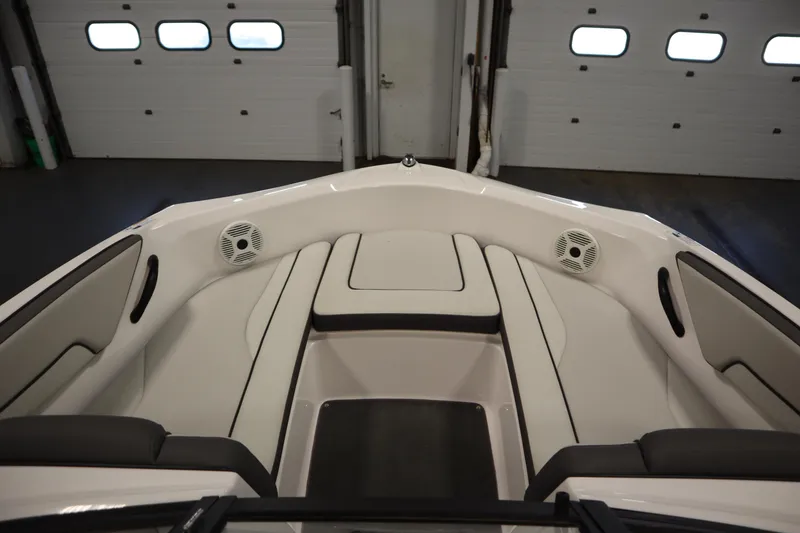 Slide: The Image of 2021 Yamaha Boats 190 AR interior with cushioned seating and speakers in a garage setting. - 11