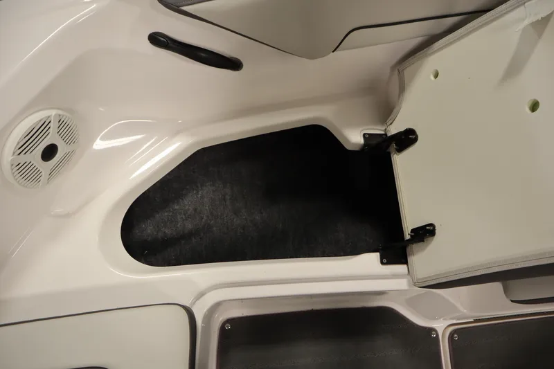 Slide: The Image of 2021 Yamaha Boats 190 AR storage compartment with open hatch and speaker. - 14