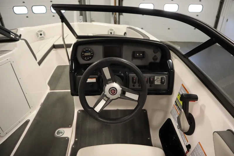 Slide: The Image of 2021 Yamaha Boats 190 AR cockpit with steering wheel and control panel. - 18