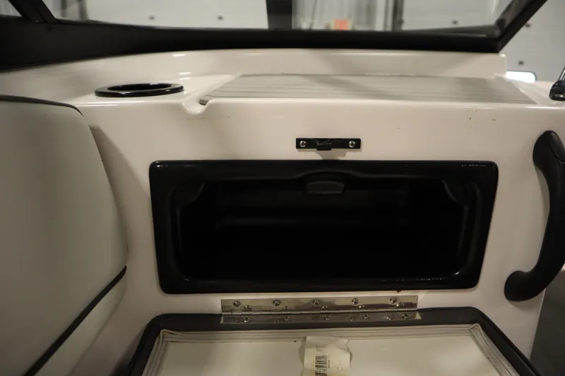 Slide: The Image of 2021 Yamaha Boats 190 AR interior storage compartment with cup holder and handle. - 31
