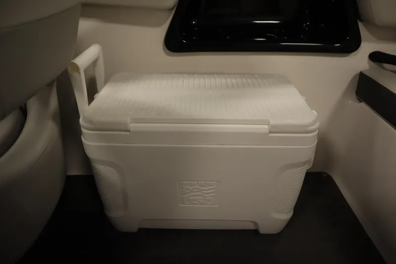 Slide: The Image of White cooler inside a 2021 Yamaha Boats 190 AR, placed on the floor. - 36