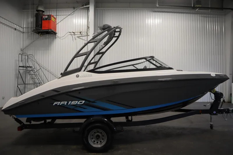 Slide: The Image of 2021 Yamaha Boats 190 AR in a showroom, side view, on a trailer. - 4
