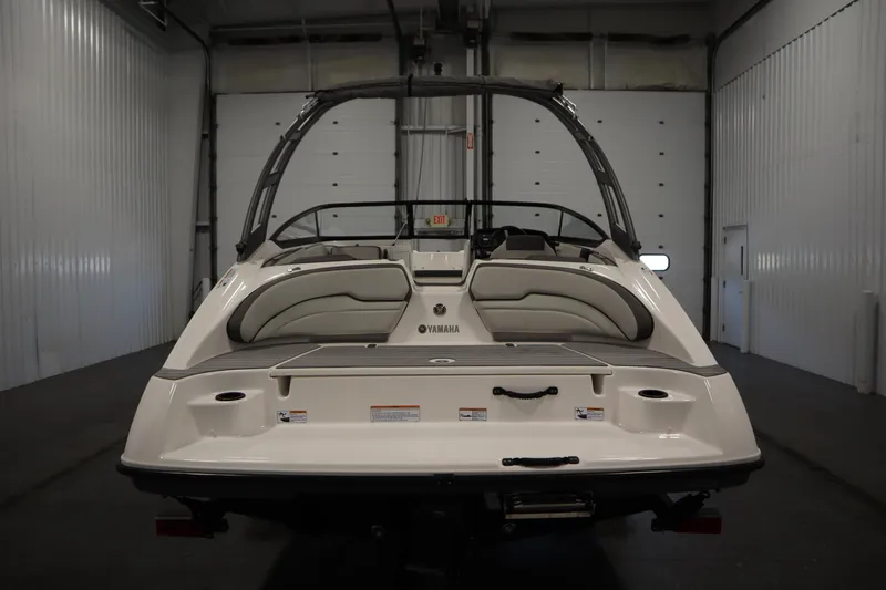 Slide: The Image of 2021 Yamaha Boats 190 AR in a garage, rear view showcasing seating and swim platform. - 6