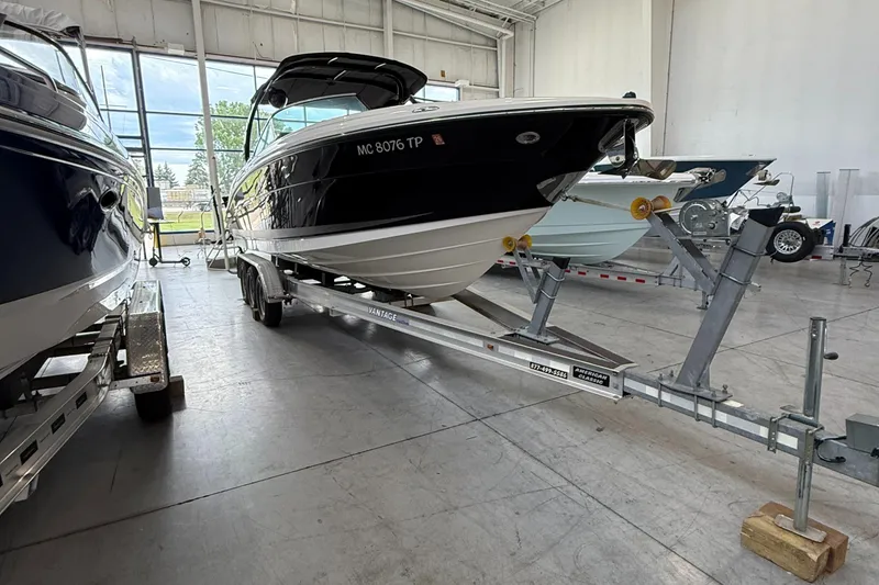 The Image of 2013 Sea Ray 270 SLX boat on trailer, parked outdoors under clear blue sky. - 0
