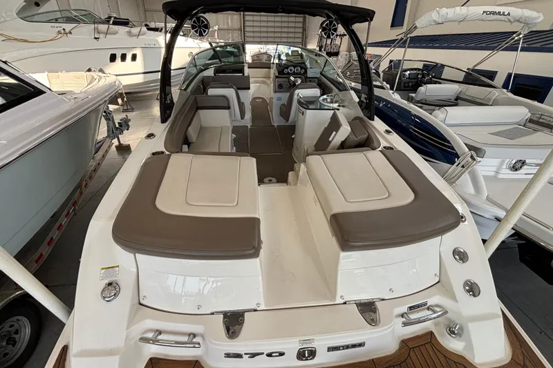 Slide: The Image of 2013 Sea Ray 270 SLX boat interior with seating and canopy in showroom. - 14