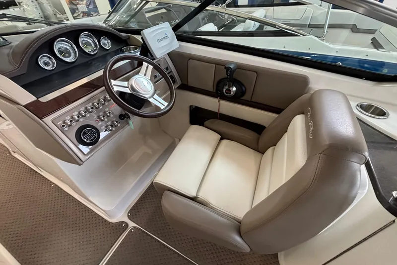 Slide: The Image of 2013 Sea Ray 270 SLX boat interior with beige seating and helm, showcasing luxury design. - 19