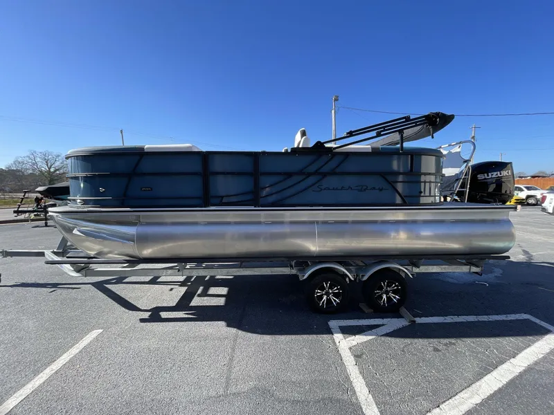 Slide: The Image of 2025 South Bay S222 RS pontoon boat on trailer, parked in sunny lot. - 29
