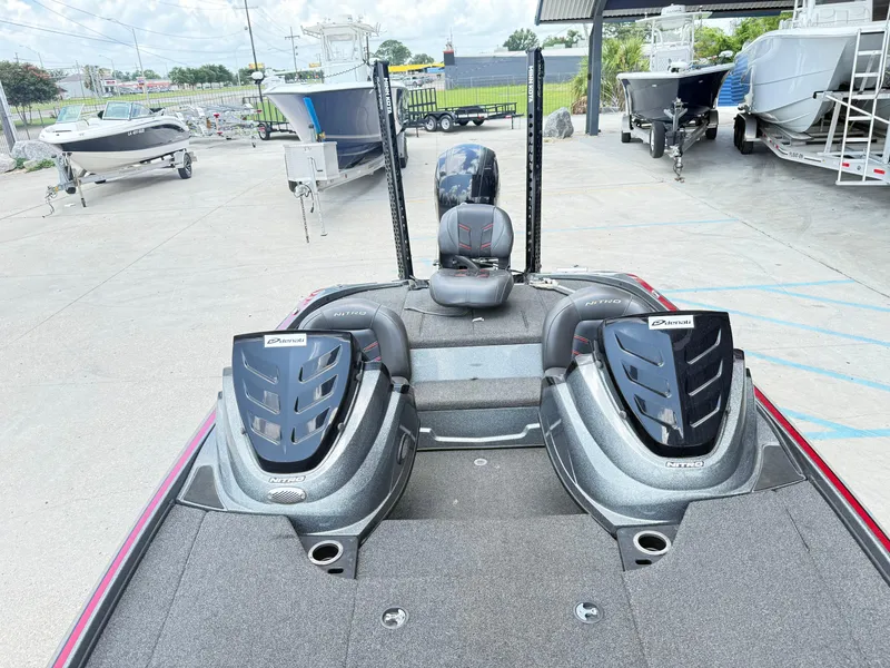 Slide: The Image of 2016 Nitro Z18 boat interior with dual seats, parked among other boats. - 17