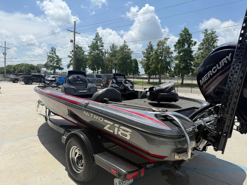 Slide: The Image of 2016 Nitro Z18 boat with Mercury engine on trailer, parked outdoors under a sunny sky. - 4