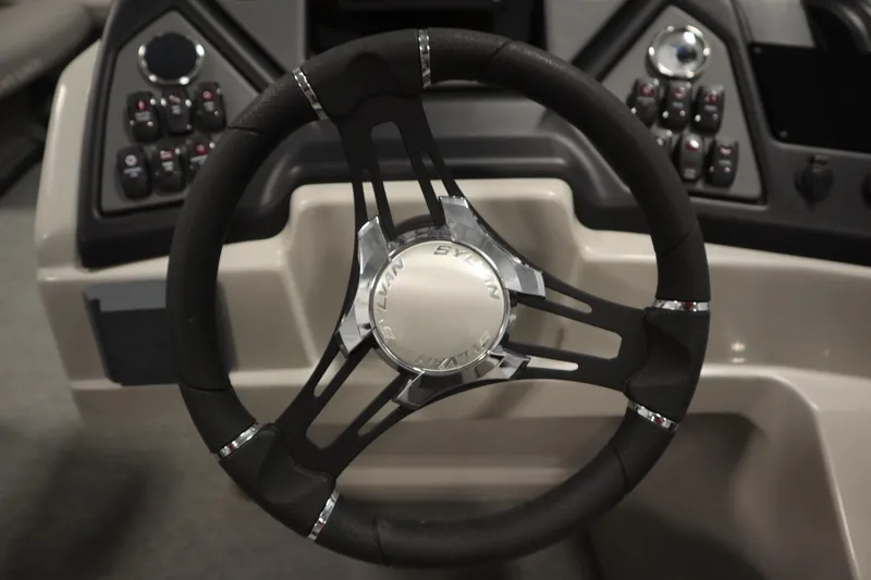 Slide: The Image of Steering wheel of 2022 Sylvan 21 L-1 CRS boat, featuring modern dashboard controls. - 13