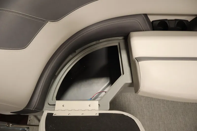 Slide: The Image of 2022 Sylvan 21 L-1 CRS boat interior storage compartment with gray and beige upholstery. - 8