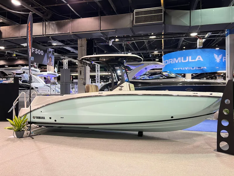 The Image of 2025 Yamaha Boats 255 FSH Sport H displayed at a boat show indoors. - 1
