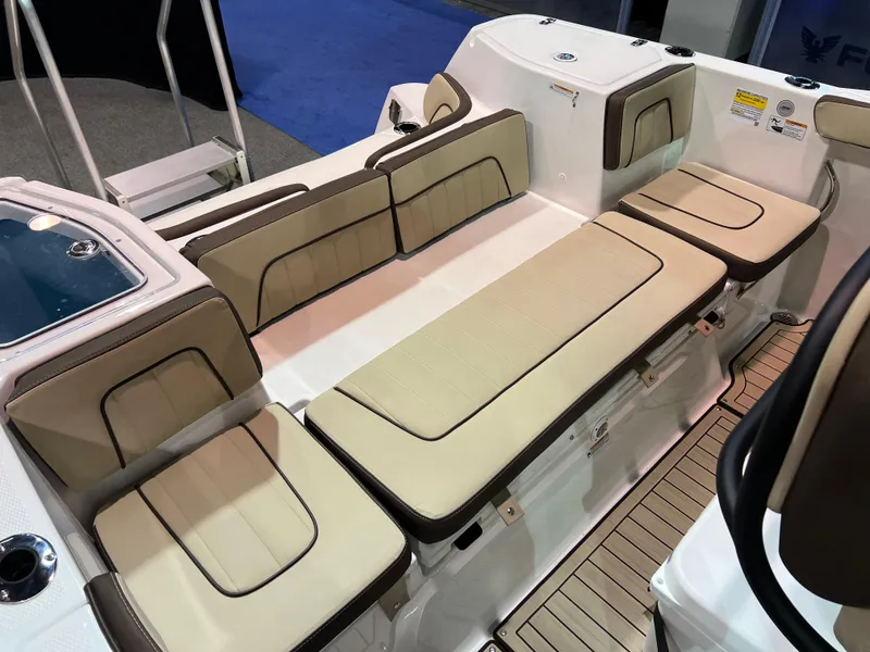 Slide: The Image of 2025 Yamaha Boats 255 FSH Sport H interior seating with beige cushions and sleek design. - 4