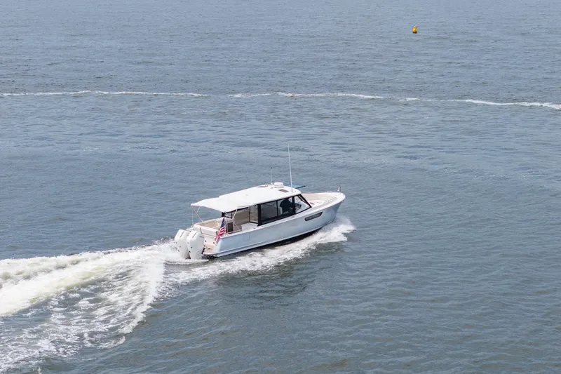 Slide: The Image of 2025 MJM 3 boat cruising on open water, leaving a wake behind. - 10