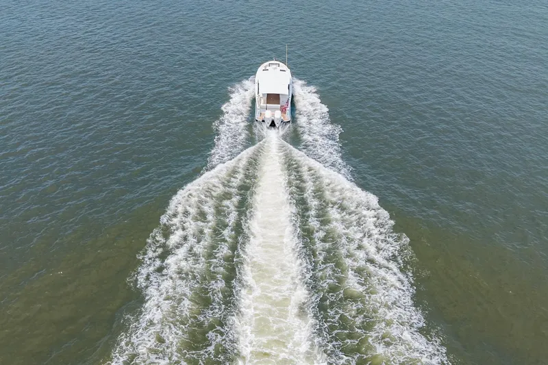 Slide: The Image of Aerial view of 2025 MJM 3 boat cruising on open water, leaving a wake. - 13