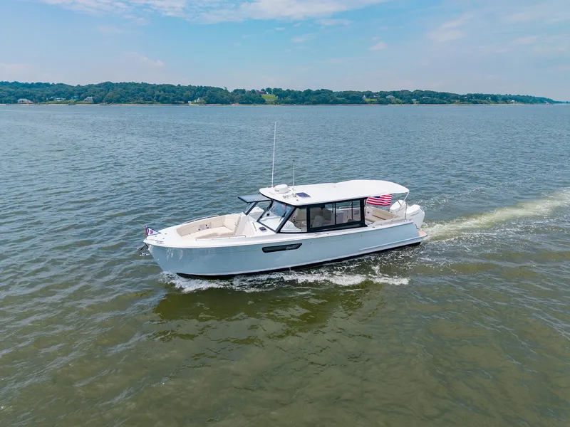 Slide: The Image of 2025 MJM 3 boat cruising on a lake under a clear blue sky. - 2