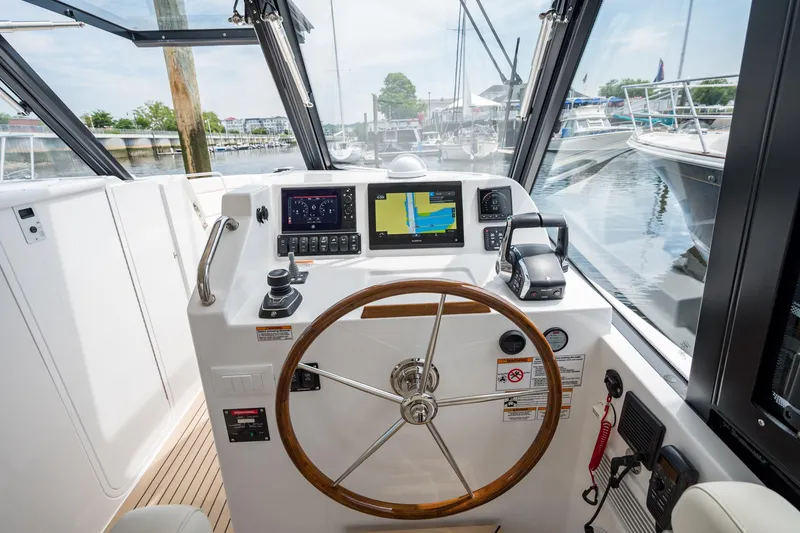 Slide: The Image of Helm of 2025 MJM 3 boat with navigation screens and wooden steering wheel. - 23