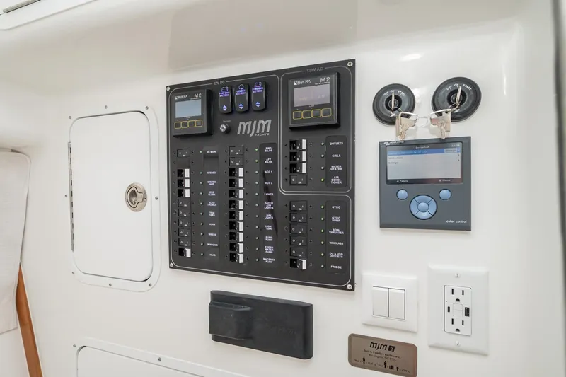 Slide: The Image of Electrical control panel on 2025 MJM 3 yacht, featuring switches and digital displays. - 30