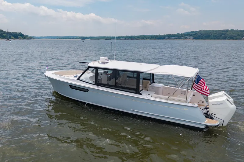 Slide: The Image of 2025 MJM 3 boat on calm water, featuring sleek design and American flag. - 4