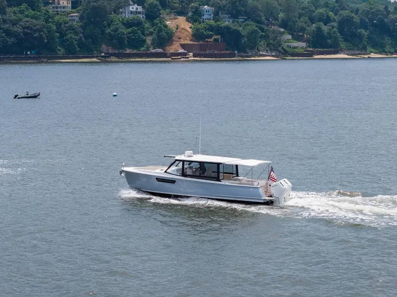 Slide: The Image of MJM 3 boat cruising on a scenic river, 2025 model. - 8