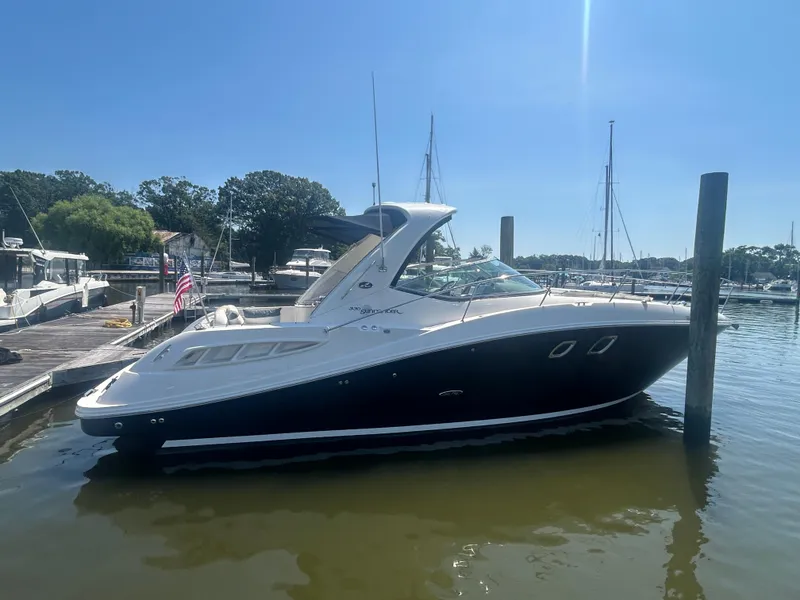 The Image of 2008 Sea Ray 330 Sundancer docked at a marina under clear blue skies. - 1