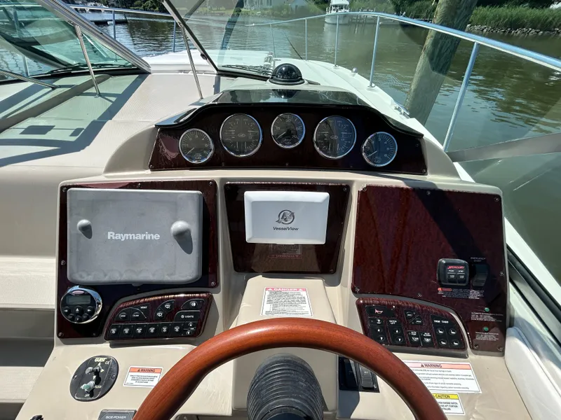 Slide: The Image of 2008 Sea Ray 330 Sundancer helm with Raymarine navigation system and wood-trimmed dashboard. - 11